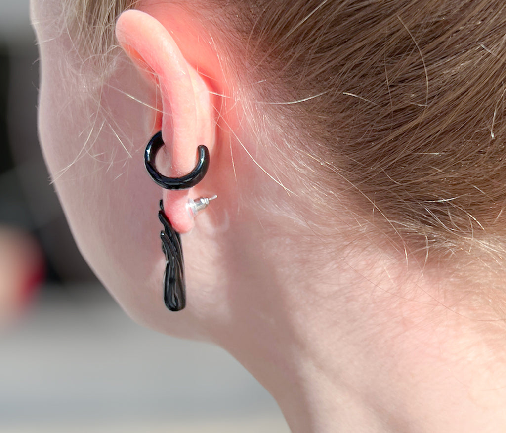 Chunky goth black ear cuff on ear with goth black hand stud earring. Hand-painted enamel.
