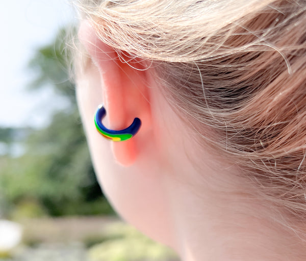 Chunky rainbow ear cuff on ear. colors : blue, green, yellow and red
